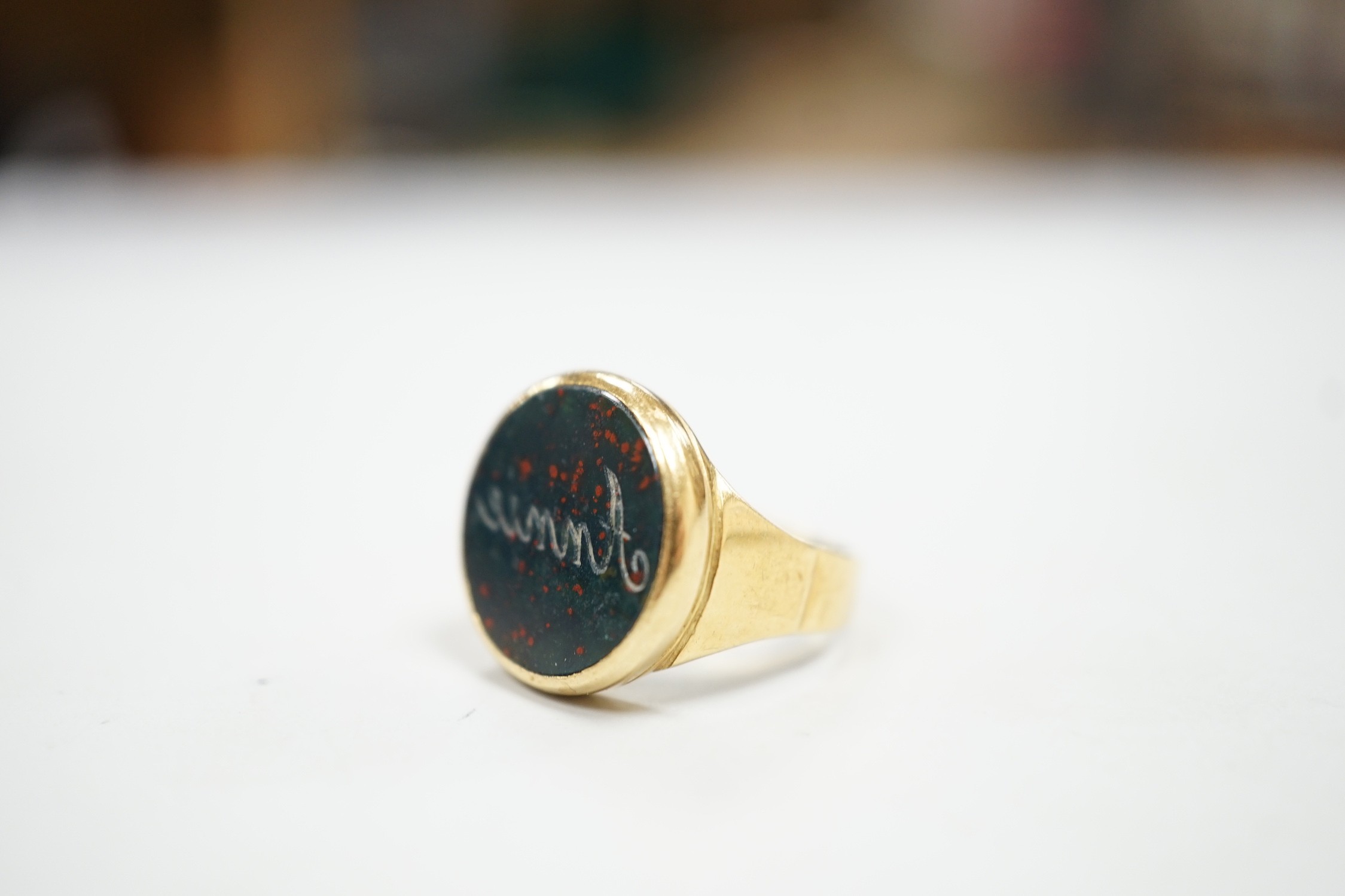 An 18ct and bloodstone set signet ring, carved with the name 'Annie', size H, gross weight 4.9 grams.